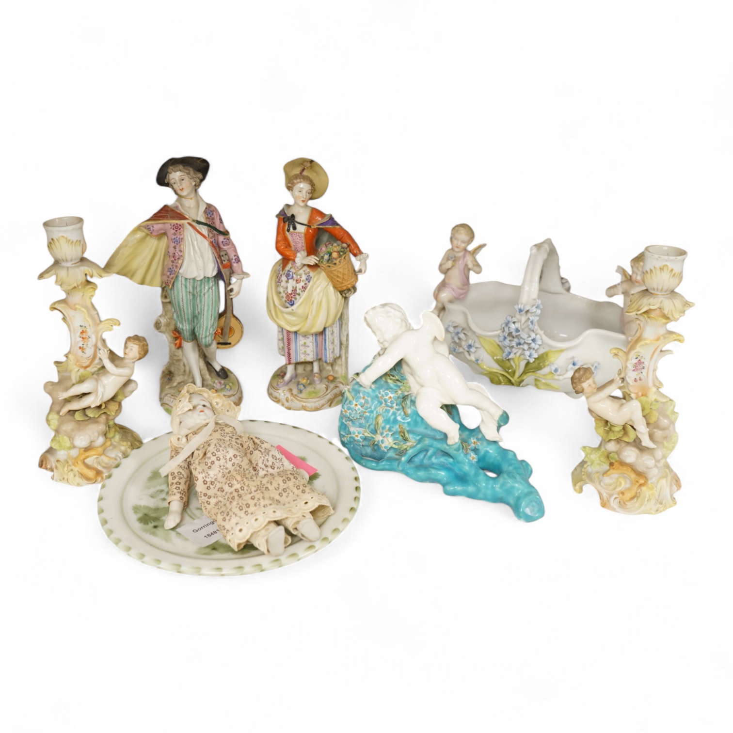A pair of Sitzendorf figurines, damage to one, a pair of candlesticks, a Rye pottery dish, a Moore Bros. wall pocket, a doll and a basket, tallest 22.5cm